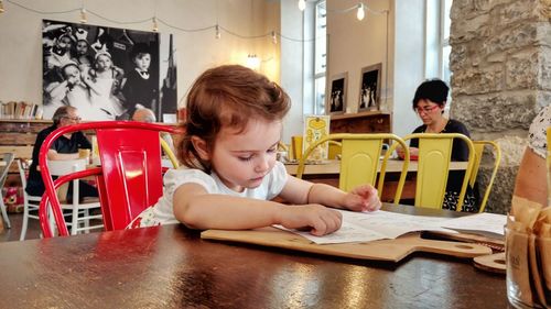 Cute girl sitting on table