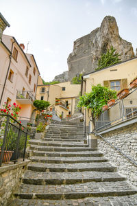 Low angle view of steps amidst buildings against sky