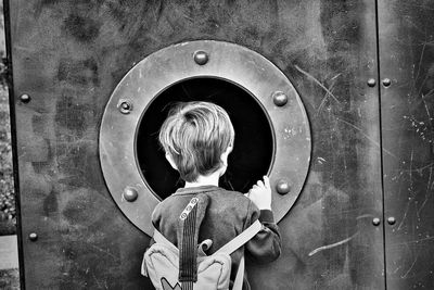 Rear view of boy looking at camera