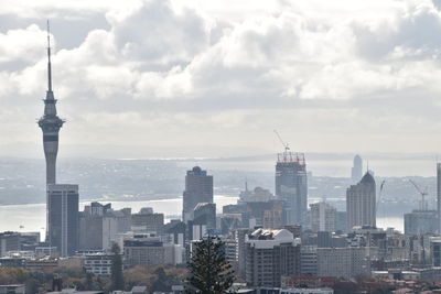 Modern buildings in city against cloudy sky