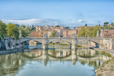 Bridge over river against built structures