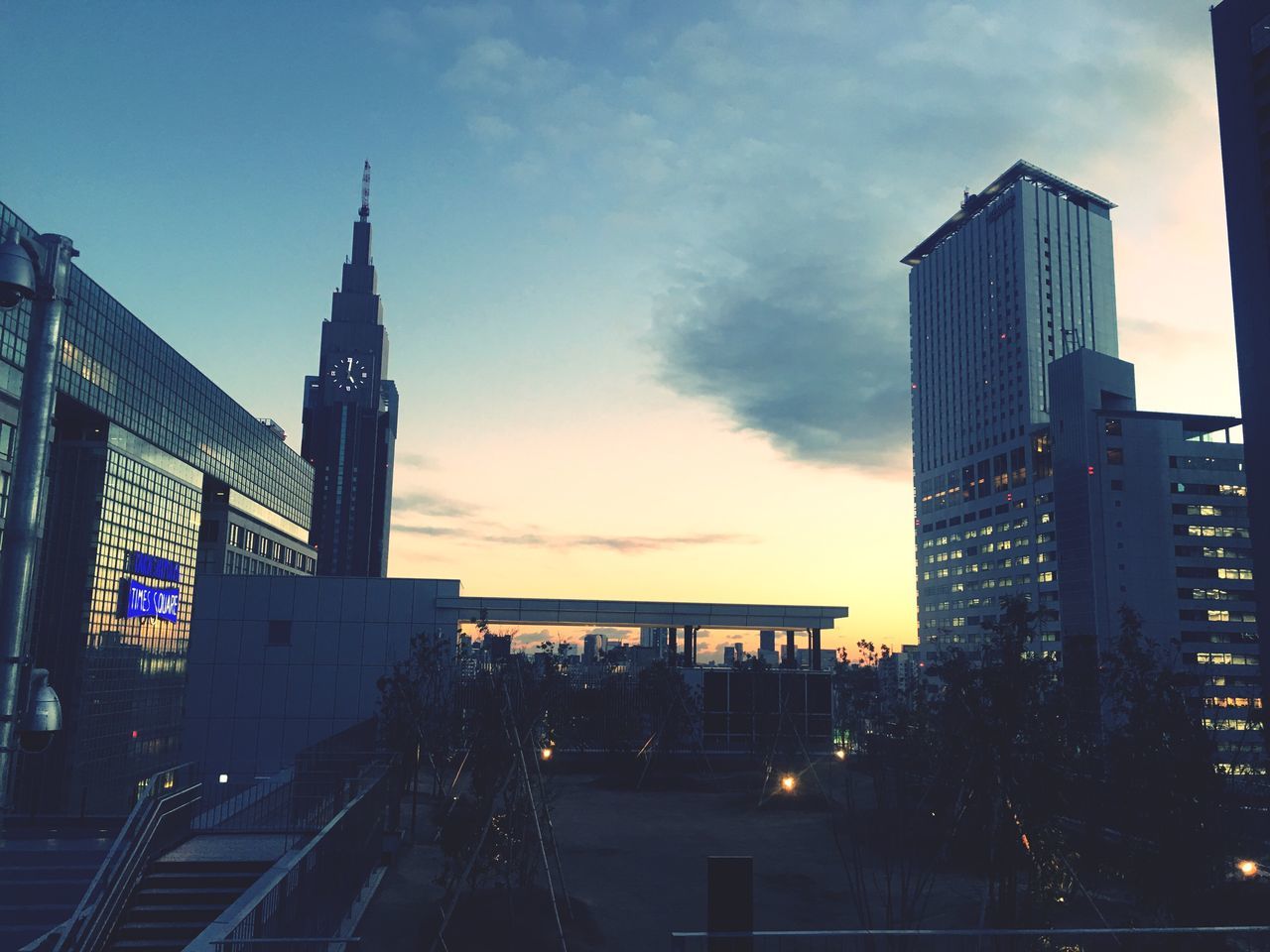 architecture, building exterior, built structure, sky, city, travel destinations, outdoors, no people, cloud - sky, sunset, skyscraper, low angle view, modern, illuminated, bridge - man made structure, clock tower, day