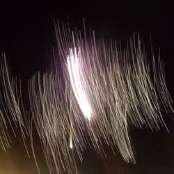 Low angle view of fireworks against sky at night