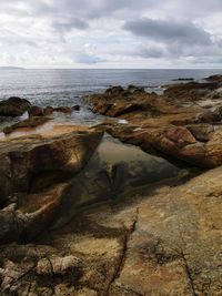 Rocks on beach against sky