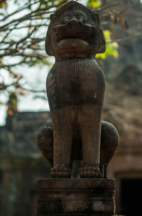 Close-up of buddha statue against stone wall