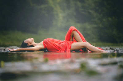 Midsection of woman relaxing in lake