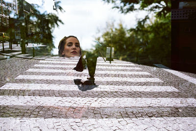 Portrait of young woman walking on footpath