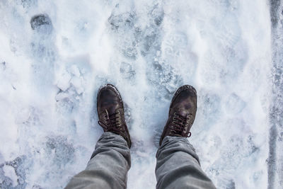 Low section of man standing on snow