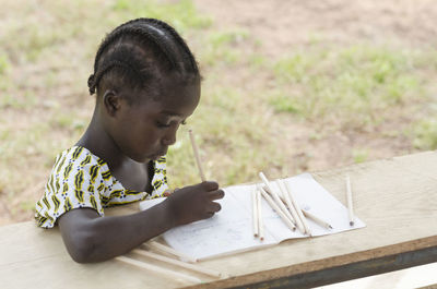 Close-up of girl writing in book