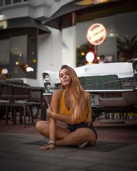 Portrait of young woman sitting outdoors