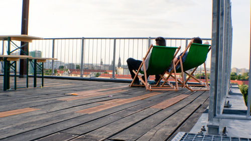 Chairs on shore against sky