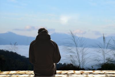 Rear view of woman standing against mountain