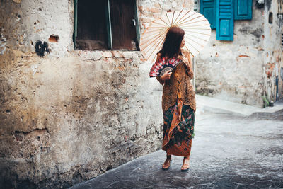 Full length of woman walking on street in city