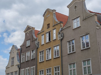 Low angle view of buildings in town against sky