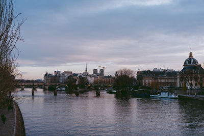 Bridge over river against buildings in city