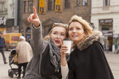 Young woman using mobile phone in city