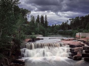 Scenic view of waterfall against sky