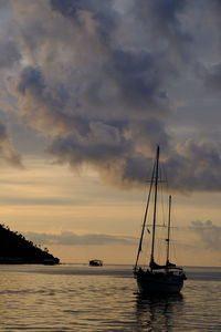 Sailboat sailing on sea against sky during sunset