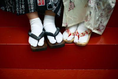 Low section of women standing on tiled floor