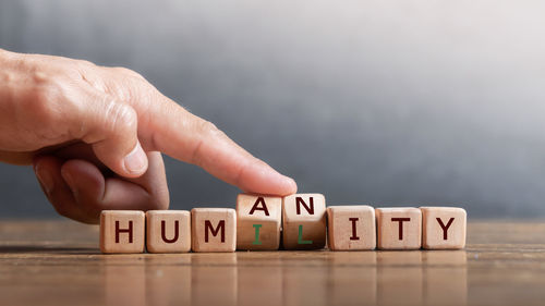 Human hand with text written on wood