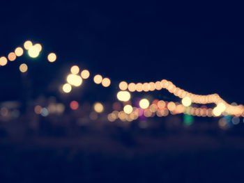 Defocused lights against clear sky at night