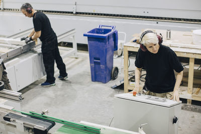 High angle view of male workers operating machines in industry