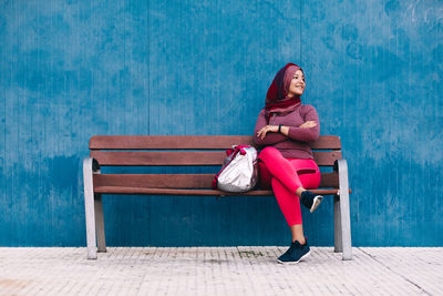 Woman looking away while sitting on bench