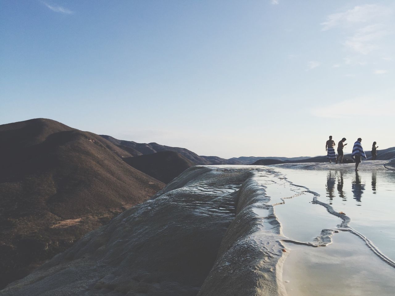 water, sky, scenics, tranquility, tranquil scene, mountain, men, nature, sea, lifestyles, beauty in nature, leisure activity, transportation, clear sky, beach, walking, incidental people, day, travel