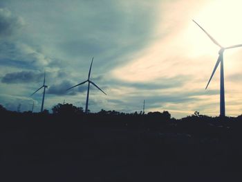 Low angle view of windmills against sky during sunset