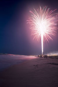 Firework display over sea at night