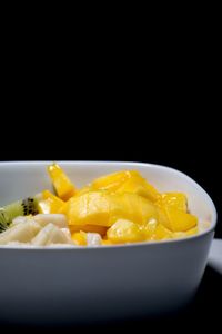 Close-up of fruits in bowl over black background