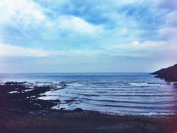 Scenic view of sea against cloudy sky