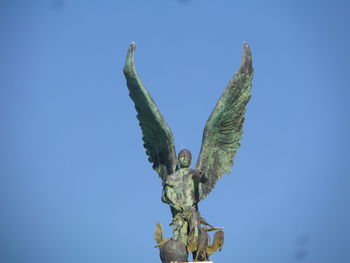 Low angle view of a bird against clear blue sky