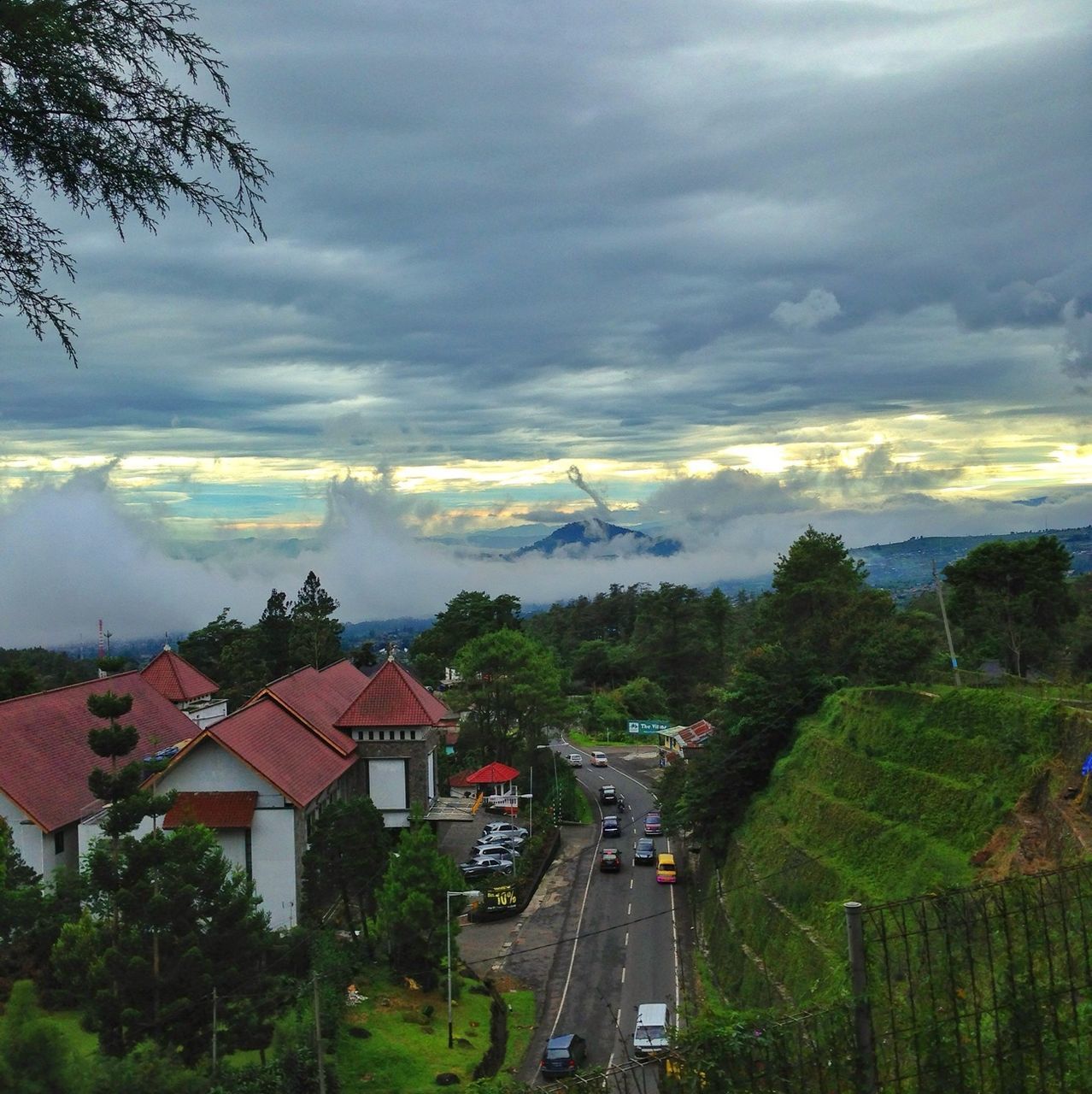 building exterior, house, architecture, sky, built structure, cloud - sky, tree, mountain, landscape, cloudy, high angle view, residential structure, scenics, town, cloud, nature, village, residential building, beauty in nature, weather