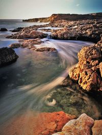 Scenic view of rocks in sea against sky