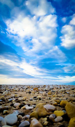 Surface level of stones on beach against sky