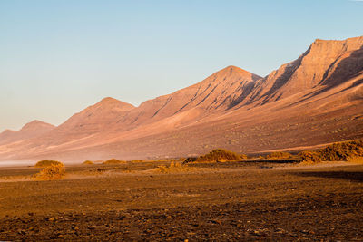 Scenic view of arid landscape against clear sky