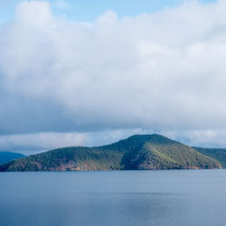 Scenic view of sea and mountains against sky