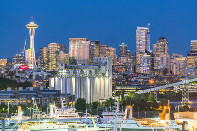 Illuminated buildings in city against clear sky