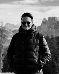 Portrait of young man standing against mountains