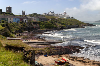 People on beach by sea against sky