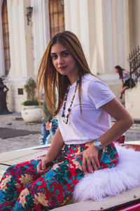 Beautiful young woman sitting outdoors