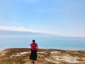 Rear view of woman standing on beach