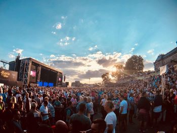 Group of people looking at concert against sky