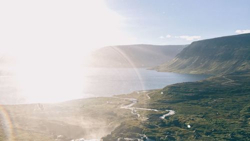 Scenic view of sea and mountains against sky