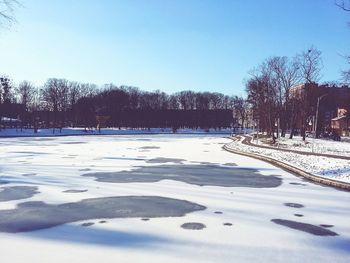 Snow covered landscape against blue sky