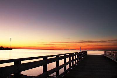 Pier on sea at sunset