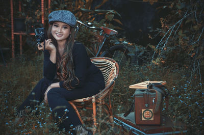 Portrait of smiling young woman sitting on field