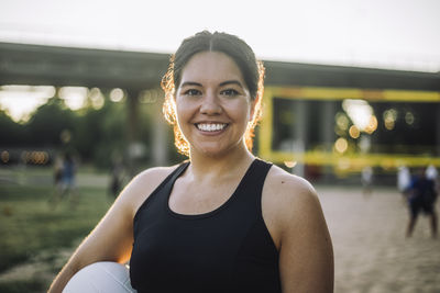 Portrait of smiling woman holding volleyball