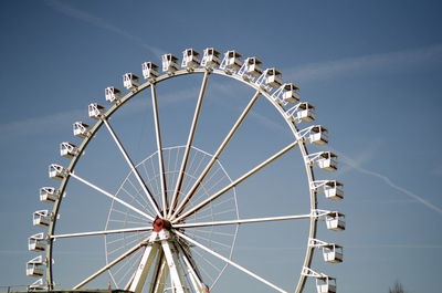 Low angle view of ferris wheel against blue sky